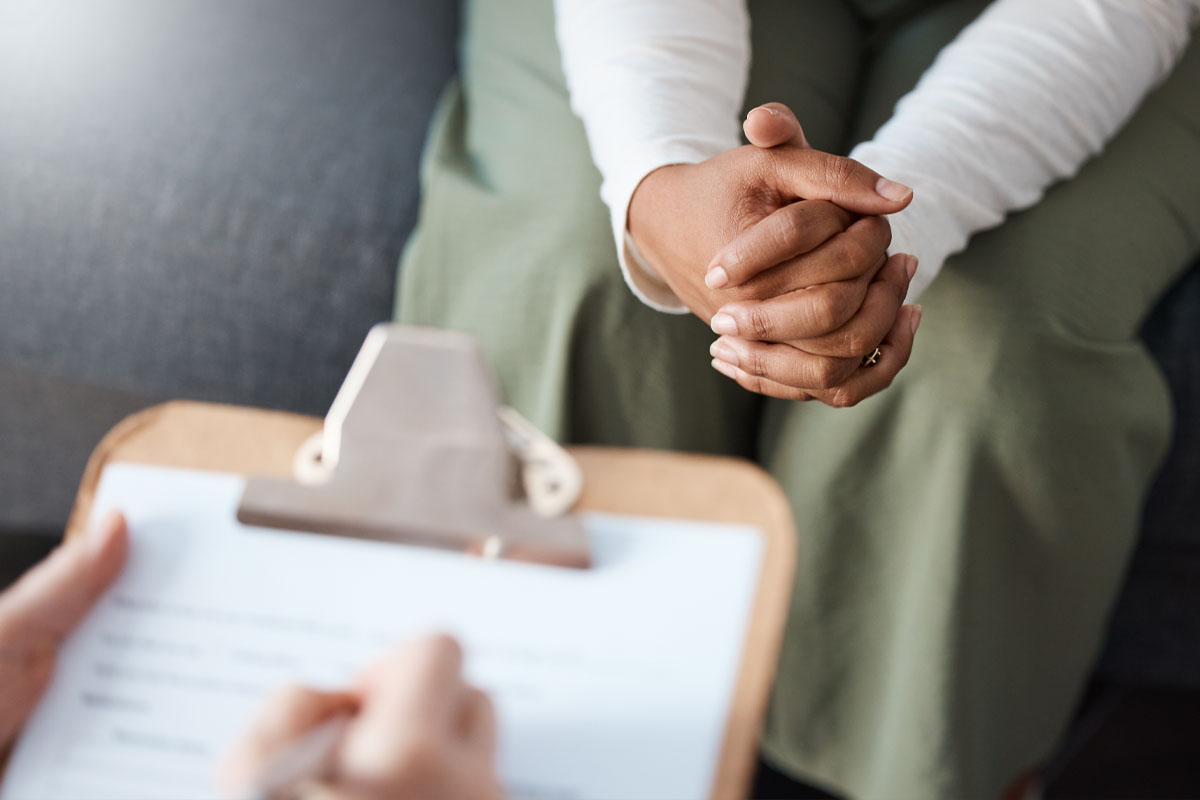 Psychologist counselling patient holding cliboard